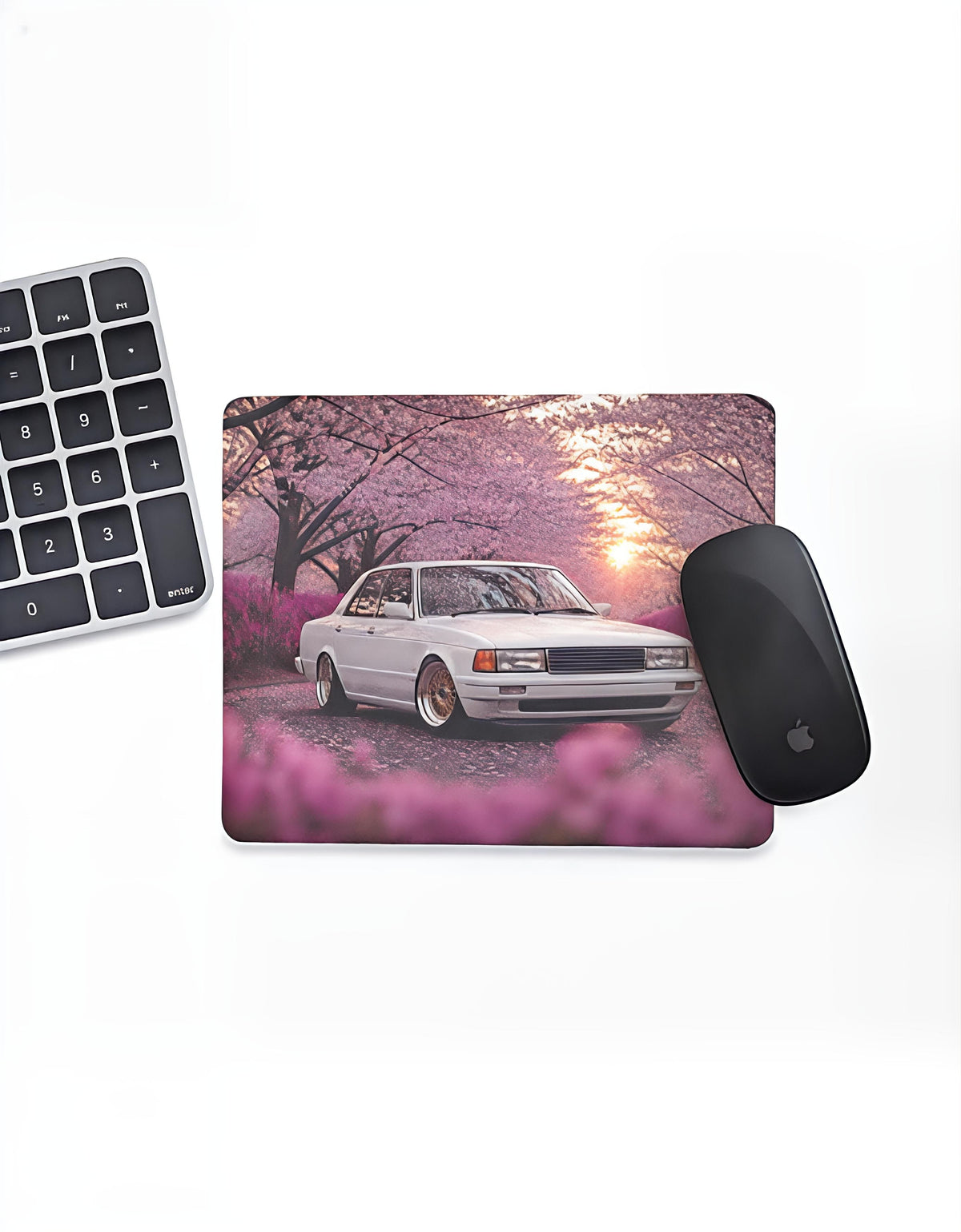 Sakura Drive mouse pad: white retro sedan under cherry blossoms at sunset, on a desk