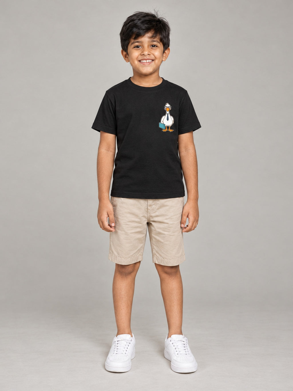 Little Kaavo kids crew tee in black, small duck pocket print, worn by a young boy, front view